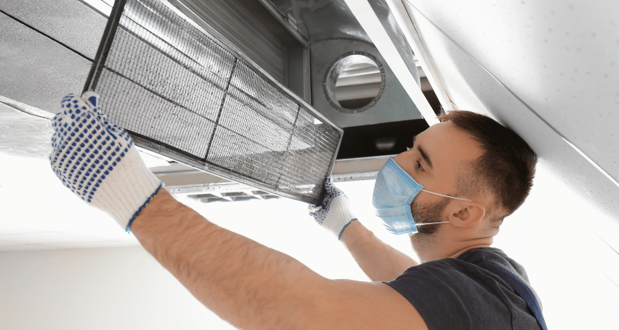 Technician inspecting air duct system in a Suffolk County home